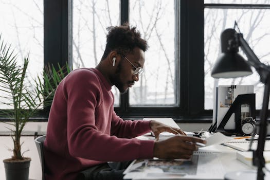 image of a person working at a desk with a computer and plants