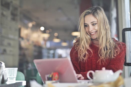 young woman working on a laptop in a coffee shop